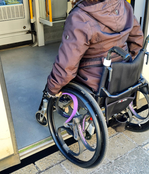 Eine Rollifahrerin beim Einstieg in eine Bahn